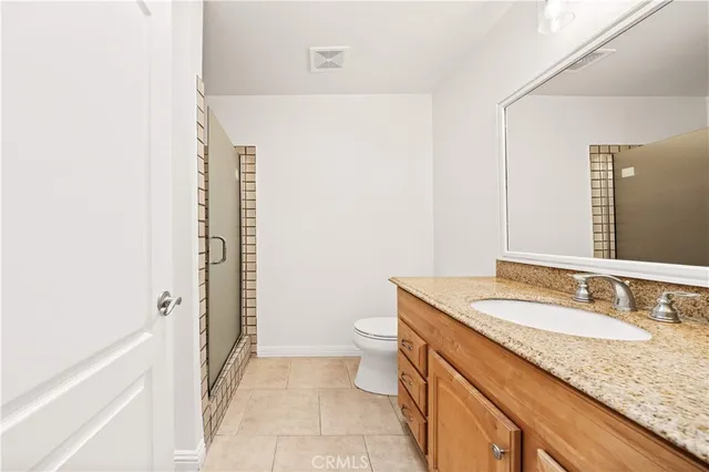 a bathroom with a granite countertop sink a toilet and shower