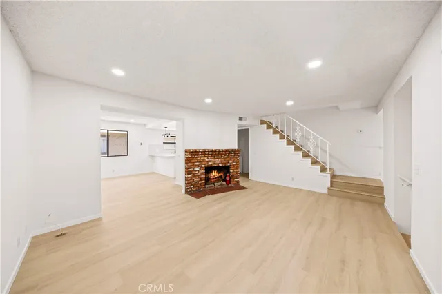 an empty room with wooden floor and hallway