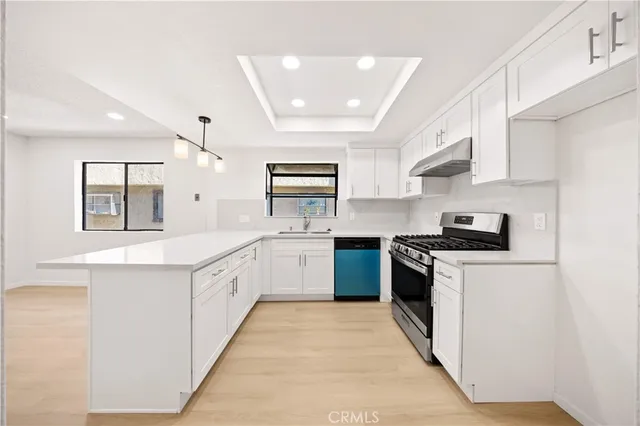 a large kitchen with stainless steel appliances lots of counter space and a sink