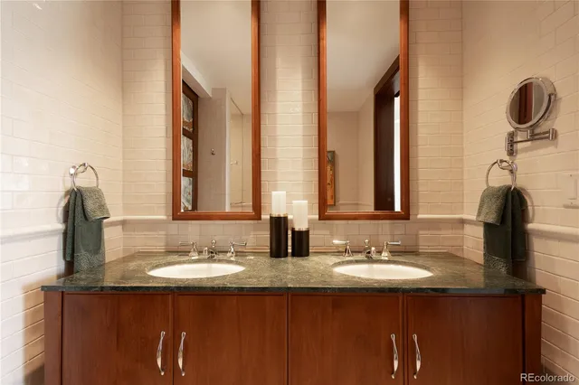 a bathroom with double vanity and a mirror