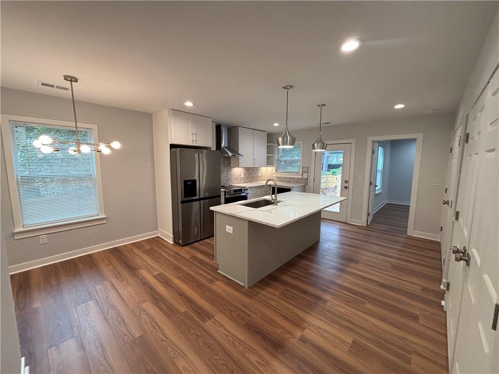 1389 Lanvale Drive Southwest Atlanta, GA 30310 - Photo 5 of 27 a large kitchen with kitchen island a island wooden floors wooden cabinets a center island and stainless steel appliances