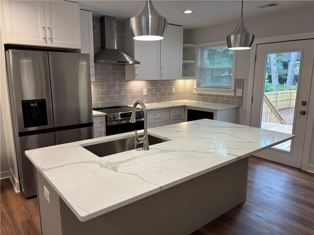 1389 Lanvale Drive Southwest Atlanta, GA 30310 - Photo 6 of 27 a kitchen with stainless steel appliances kitchen island granite countertop a refrigerator a sink a stove and wooden cabinets