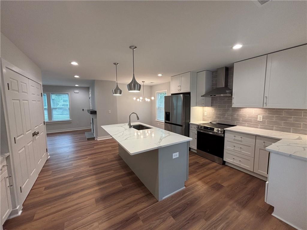 1389 Lanvale Drive Southwest Atlanta, GA 30310 - Photo 7 of 27 a large kitchen with stainless steel appliances kitchen island a large counter top and wooden floors