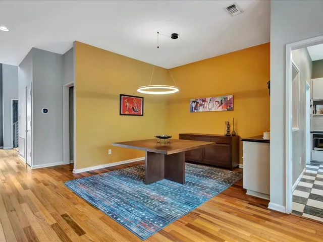 a view of a living room with a rug and wooden floor