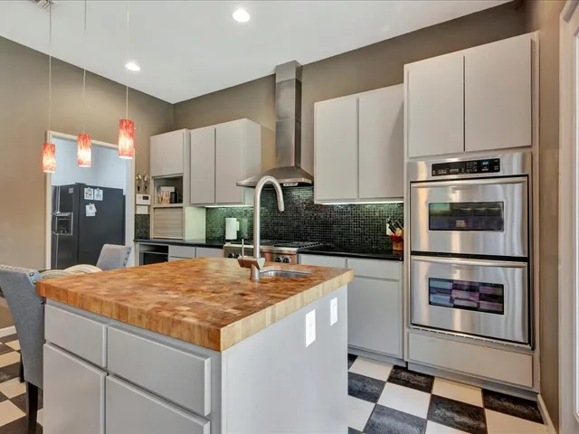 a kitchen with stainless steel appliances granite countertop a refrigerator and a stove