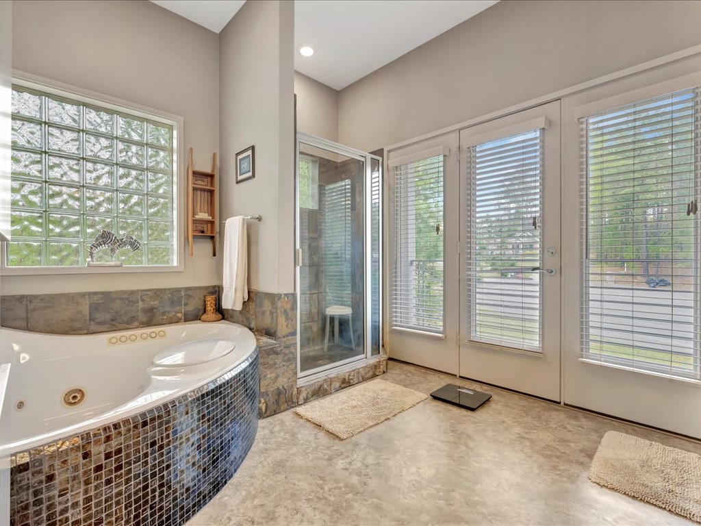 3418 St George Circle Nacogdoches, TX 75965 - Photo 36 of 50 a bathroom with a tub a sink and a large window