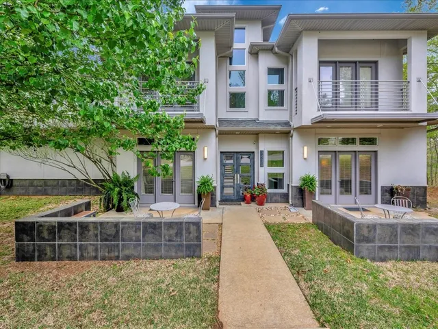a view of a brick building with a large window and plants
