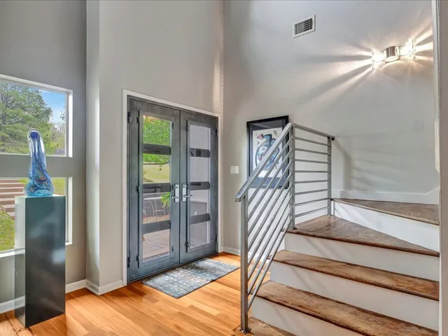 a view of a bedroom with wooden floor and windows