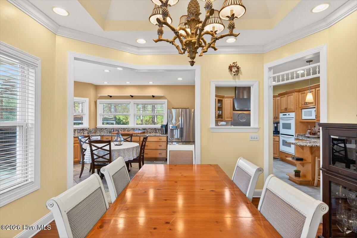 18 Brierwood Road Southwest Shallotte, NC 28470 - Photo 15 of 70 Formal dining room with tray ceiling and chandelier—perfect for hosting dinners and special occasions.