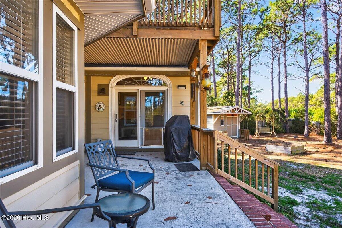 18 Brierwood Road Southwest Shallotte, NC 28470 - Photo 30 of 70 Covered wraparound porch offering shaded outdoor living and serene views of the landscaped lot.