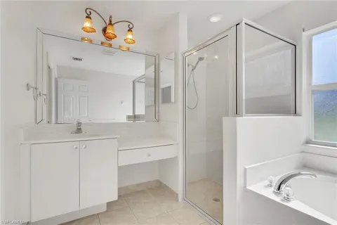 a bathroom with a sink vanity granite tub and shower