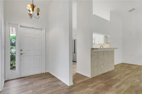 a view of a kitchen with wooden floor cabinets and entryway