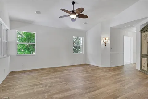 an empty room with fan and windows