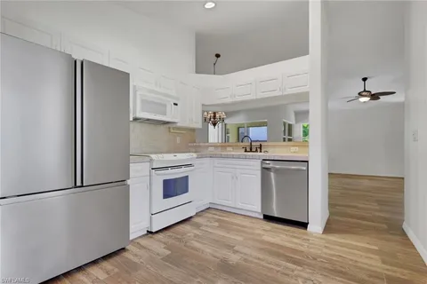 a kitchen with a refrigerator stove and white cabinets