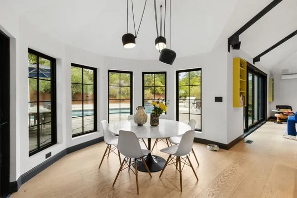 a view of a dining room with furniture large windows and wooden floor