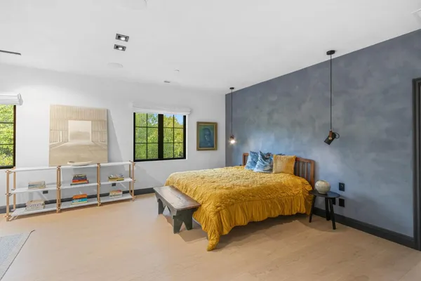 a bedroom with a bed and a large window