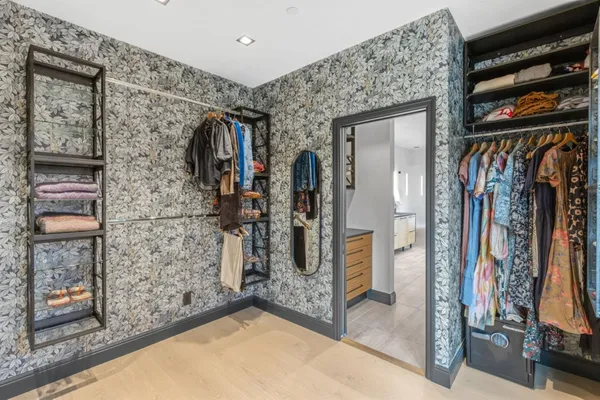 a view of walk in closet with clothes and shoes