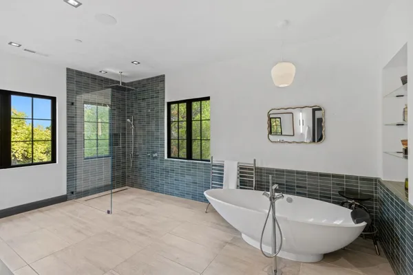 a bathroom with a tub sink and mirror