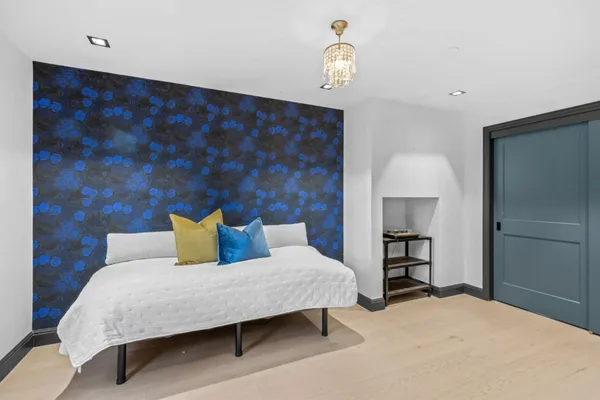 a bedroom with a bed and a lamp with the wooden floor