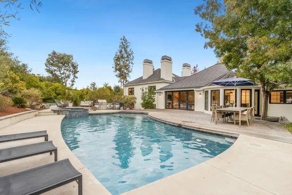 a view of a house with swimming pool and sitting area