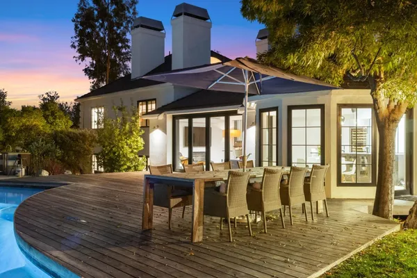a patio with table and chairs and potted plants
