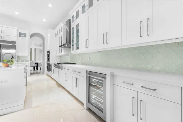 a kitchen with stainless steel appliances granite countertop a stove and white cabinets