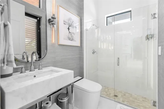 a bathroom with a sink a toilet and shower