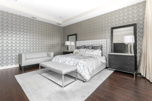 a bedroom with a bed wooden floor and lamp