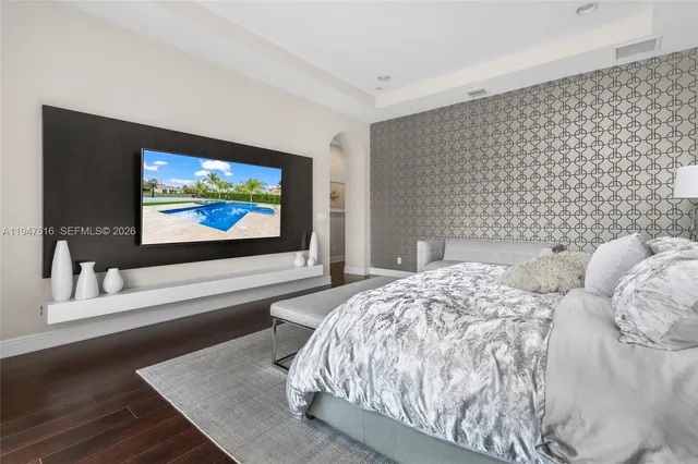 a bedroom with a bed and a flat screen tv