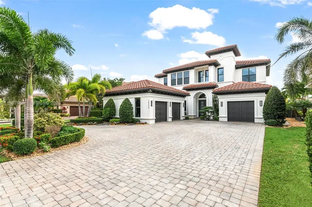 a front view of a house with a yard and potted plants