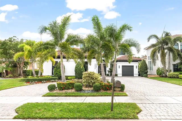 a front view of a house with a yard garage and outdoor seating