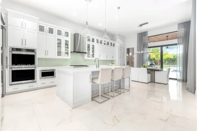 a kitchen with stainless steel appliances kitchen island granite countertop a refrigerator and a stove top oven