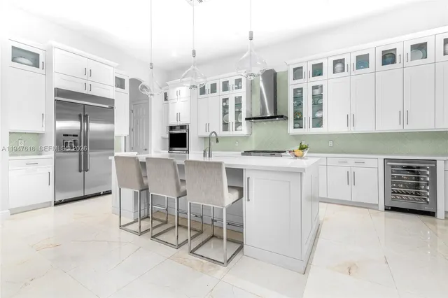 a kitchen with stainless steel appliances kitchen island granite countertop a stove a cabinets a sink and a refrigerator