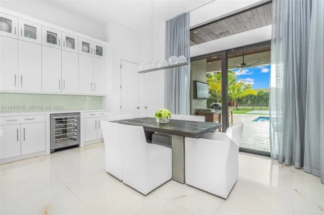 a kitchen with stainless steel appliances a white table and chairs