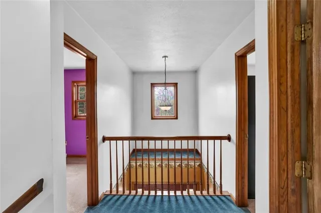 a view of a hallway with wooden floor and windows