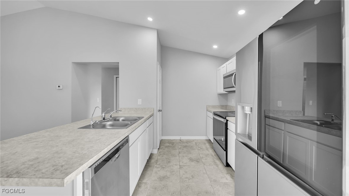767 Roma Avenue South Lehigh Acres, FL 33974 - Photo 19 of 34 a kitchen with a sink stove and refrigerator