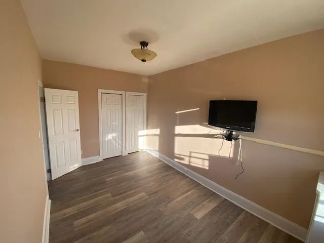 a view of room with wooden floor and flat screen tv