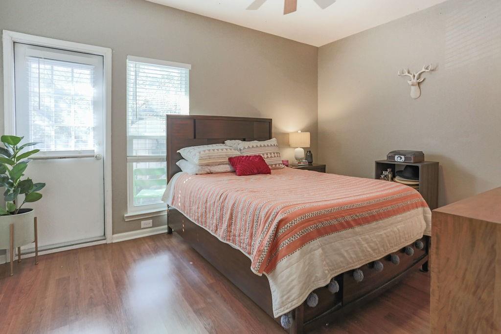 1307 Kinney Avenue, Unit 121 Austin, TX 78704 - Photo 9 of 12 a bedroom with a bed a potted plant on dresser and a wooden floor