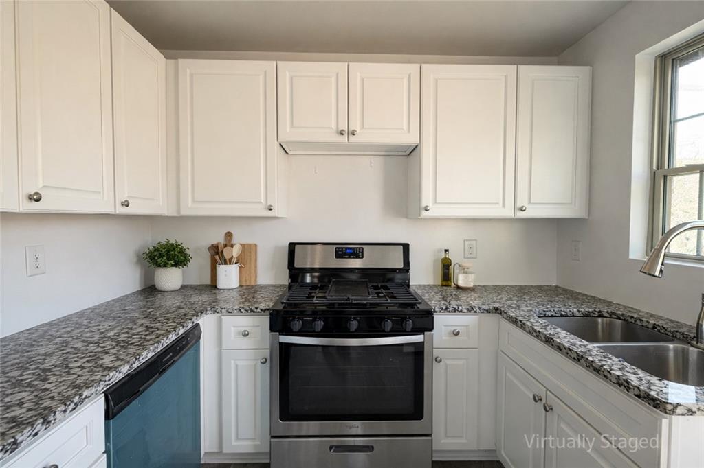 1488 East Forrest Avenue Atlanta, GA 30344 - Photo 2 of 7 a kitchen with granite countertop white cabinets and stainless steel appliances