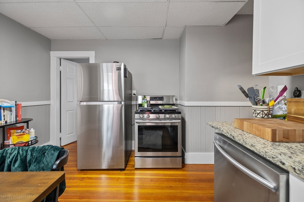 14-16 Malvern Avenue Somerville, MA 02144 - Photo 7 of 39 a kitchen with stainless steel appliances granite countertop a refrigerator and a sink