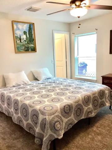 a bedroom with a bed and a painting on the wall
