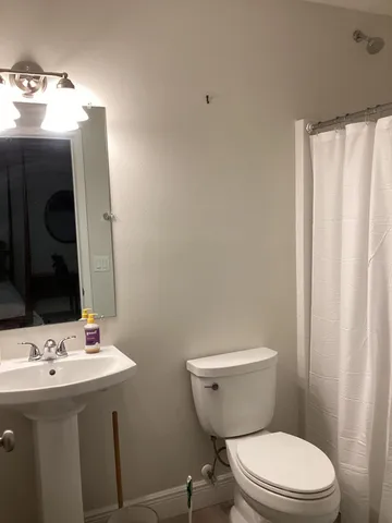 a bathroom with a toilet a sink and mirror