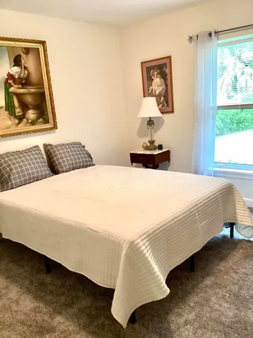 a bedroom with a bed and a painting on the wall