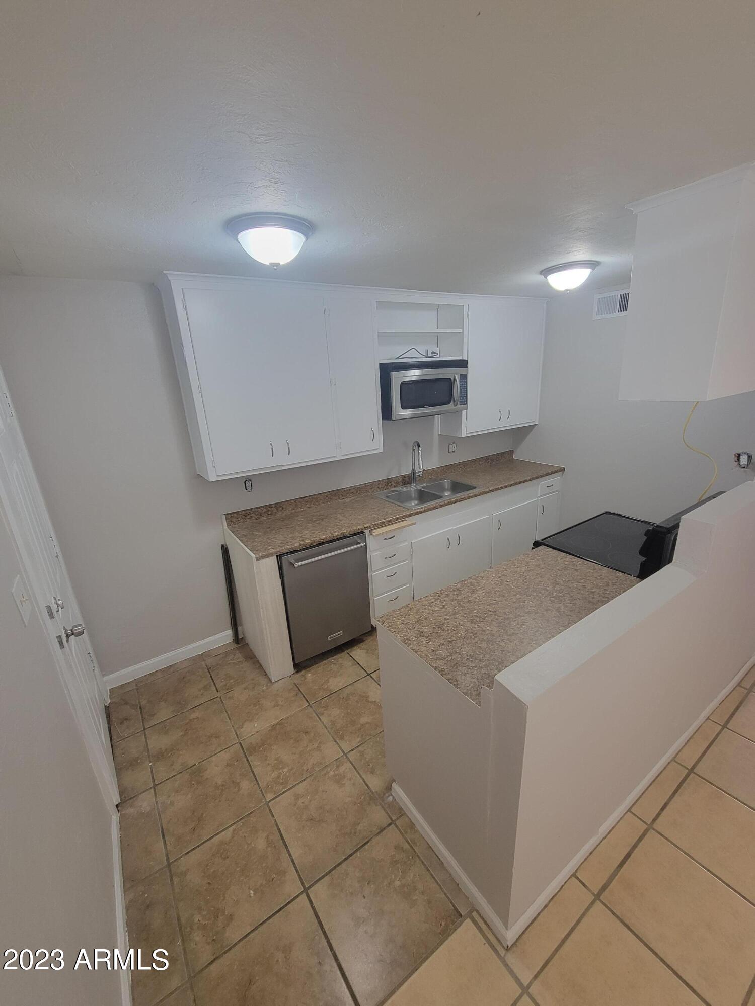 6518 North 41st Avenue Phoenix, AZ 85019 - Photo 4 of 13 a kitchen with a sink a stove and cabinets