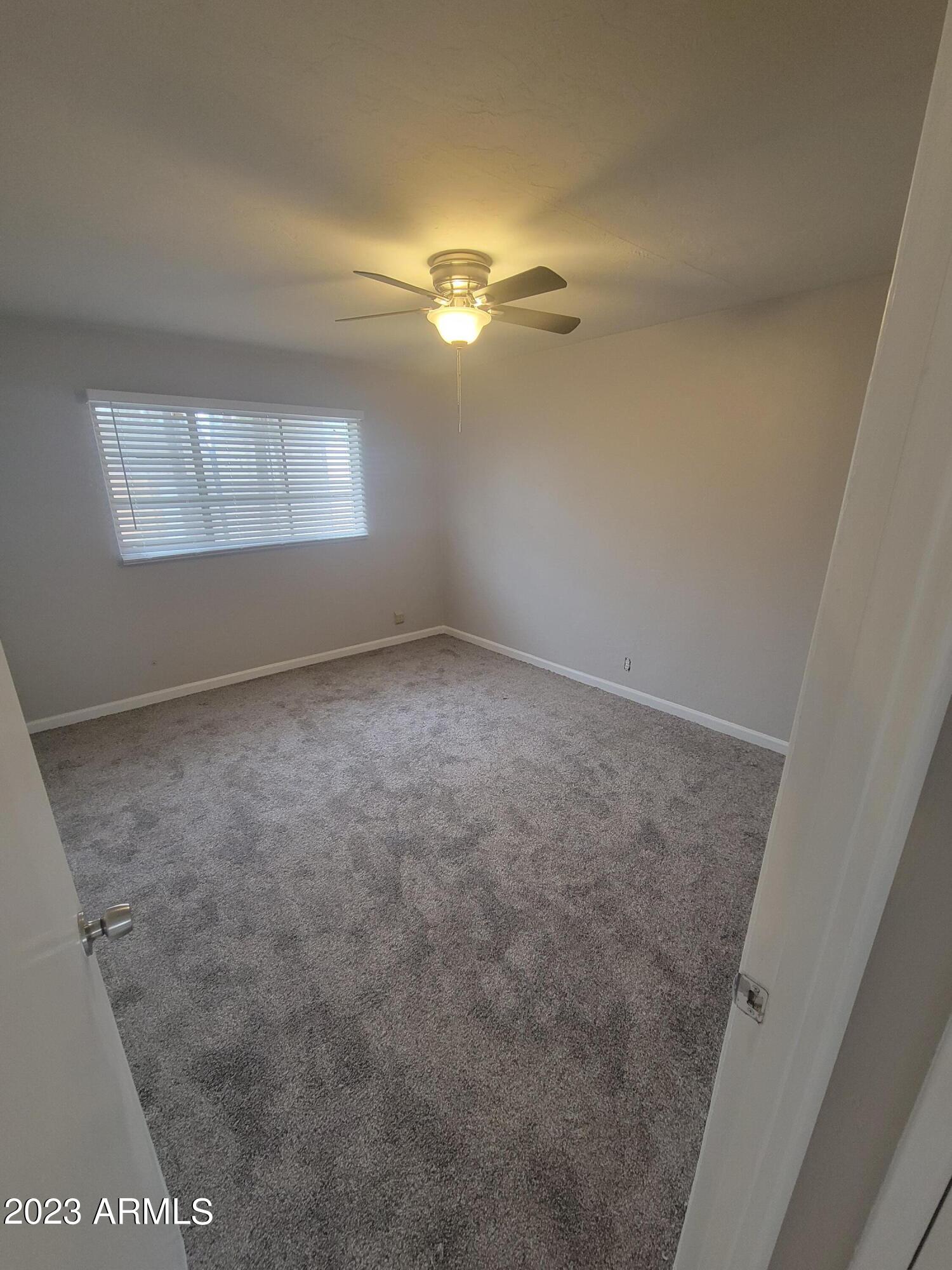 6518 North 41st Avenue Phoenix, AZ 85019 - Photo 10 of 13 en empty room with windows and ceiling fan