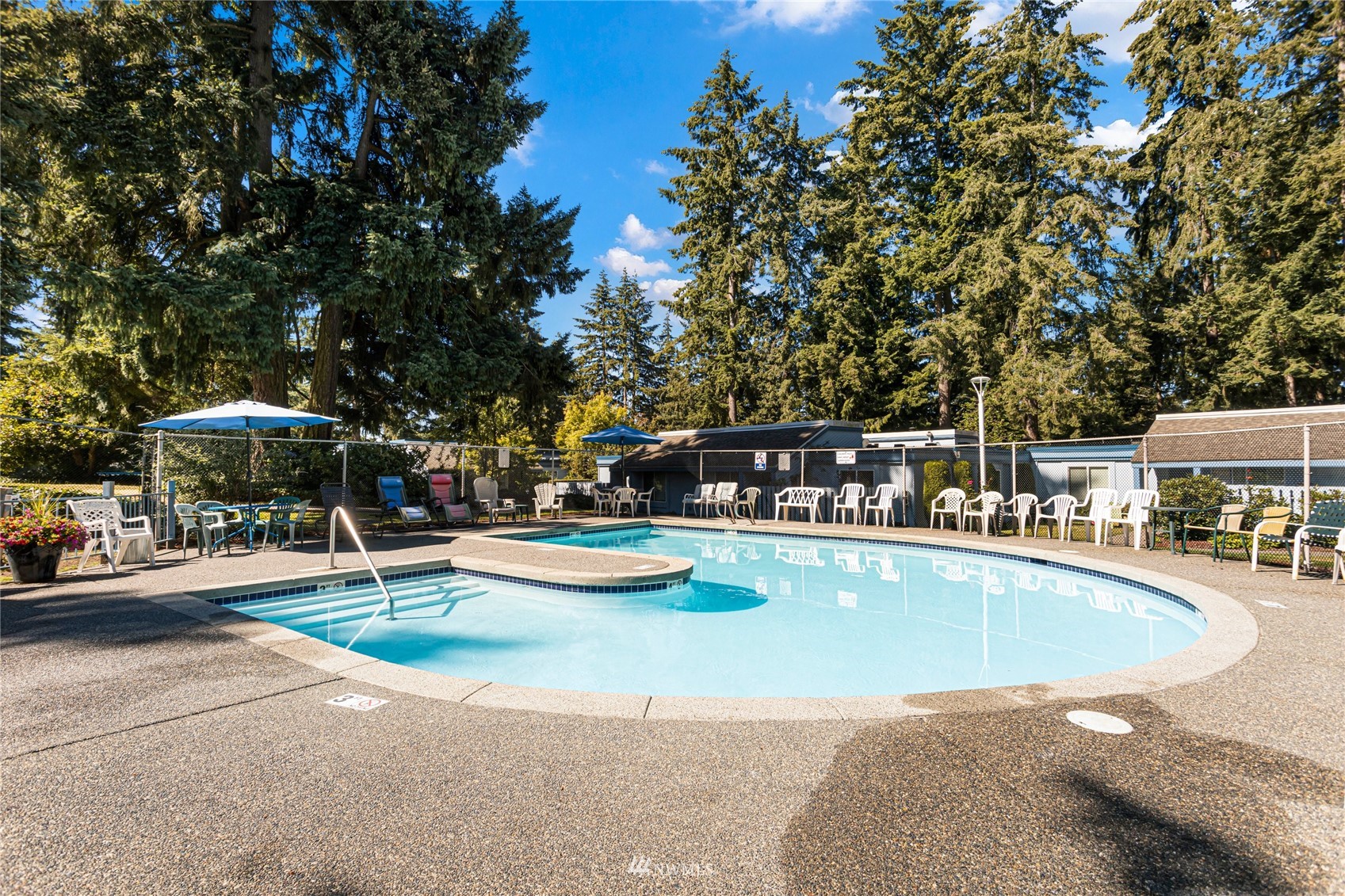 4308 Northeast Sunset Boulevard, Unit O2 Renton, WA 98059 - Photo 20 of 22 a view of a swimming pool with a table and chairs under an umbrella