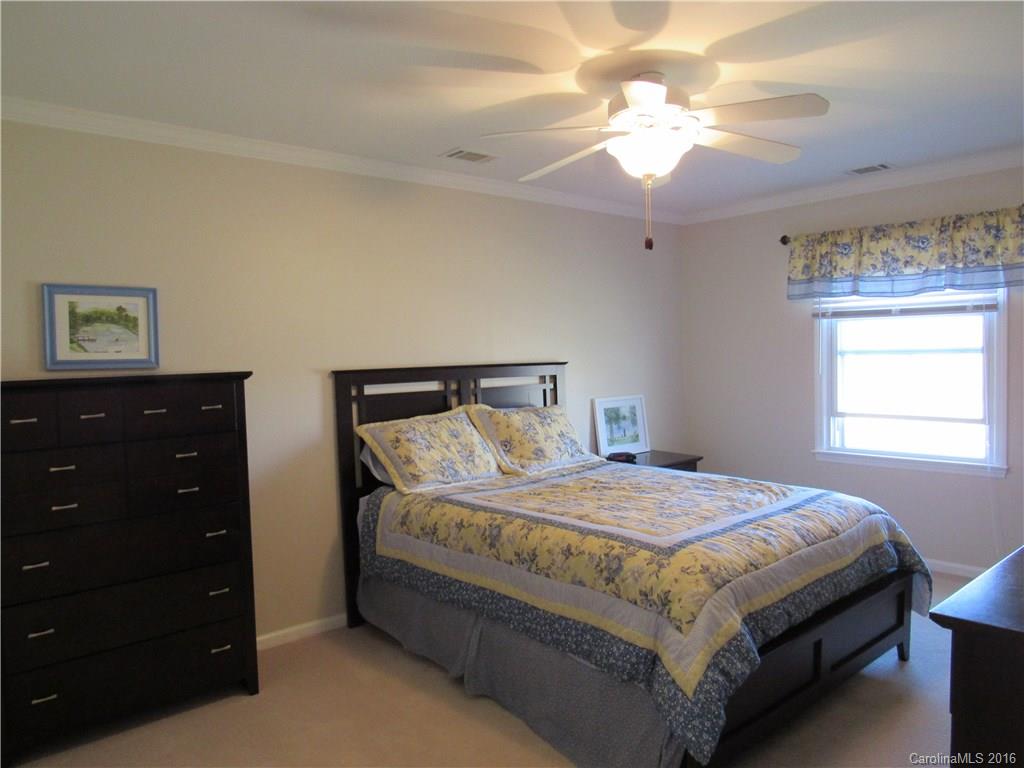 1219 Stevens Road Monroe, NC 28110 - Photo 21 of 24 a bedroom with a bed and a chandelier