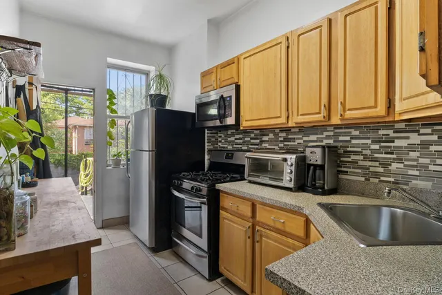 a kitchen with stainless steel appliances granite countertop a refrigerator a stove a sink and dishwasher