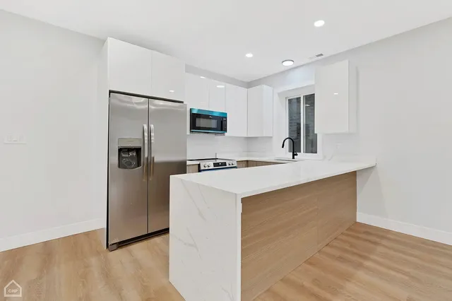 a kitchen with stainless steel appliances a refrigerator sink and microwave
