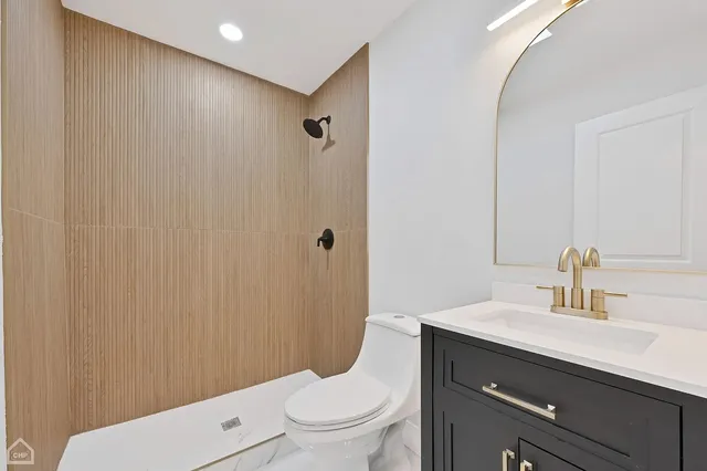 a bathroom with a sink a toilet and shower